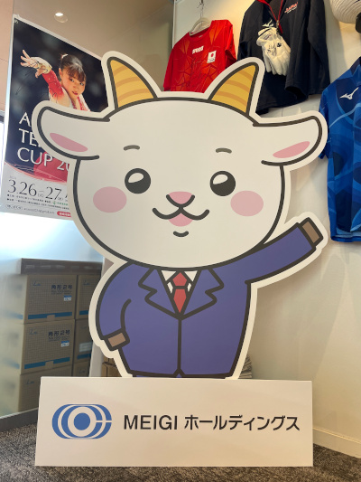 株式会社MEIGIホールディングスの企業マスコット「メェーギくん」の等身大パネルです。大きさは160cmほどになります。メェーギくんの足元には、社名とロゴが入ったパネルが置いてあります。